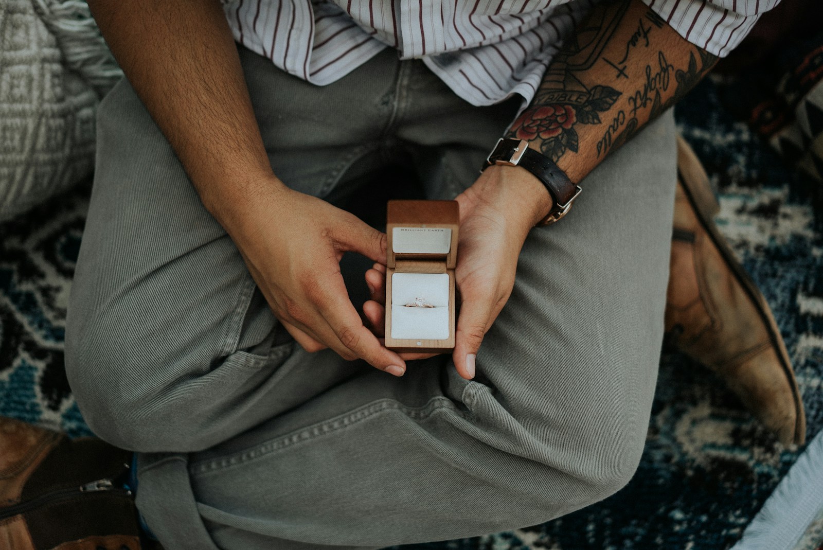 person holding opened brown ring box